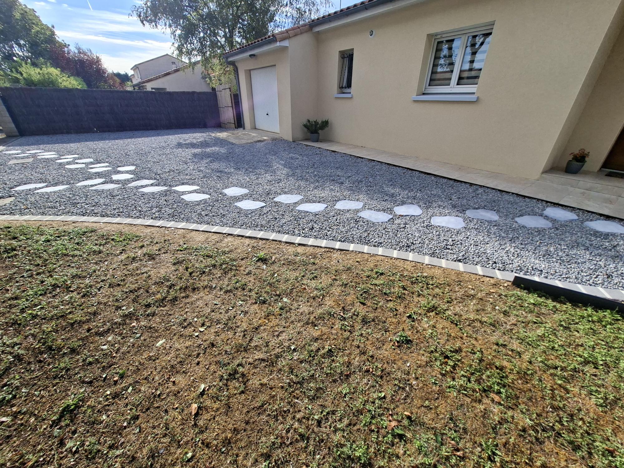 Allée de passage entre maisons avec haie